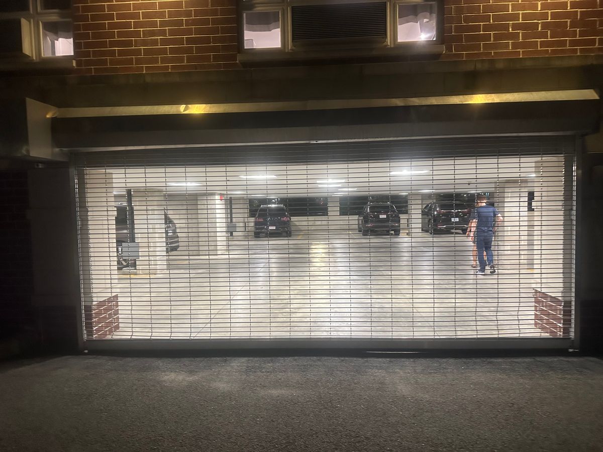Commercial roll-up security grille door on parking garage at night